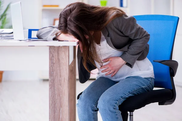 Pregnant woman struggling with pain in office — Stock Photo, Image