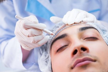 Doktor estetik ameliyattan önce hastaların yüzlerini ölçüyor