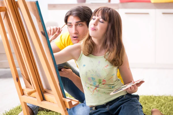 Pareja joven disfrutando de la pintura en casa — Foto de Stock