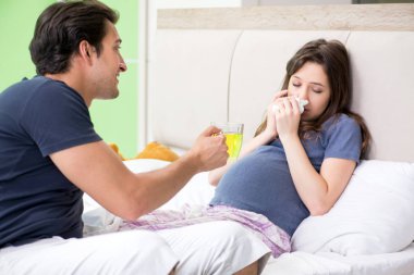 Genç koca hamile karısına bakıyor.