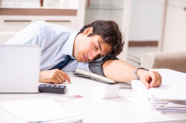 Stres altındaki adam kan basıncını ölçüyor.