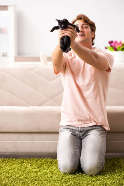 Jeune homme jouant avec chaton à la maison — Photo