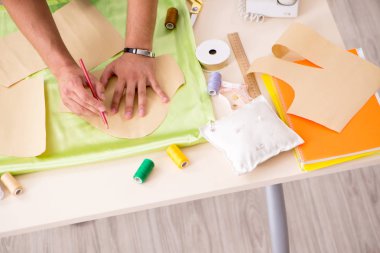 Atölyesinde çalışan yakışıklı bir terzi.