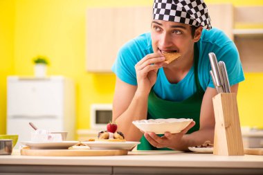 Adam evde pasta hazırlıyor.