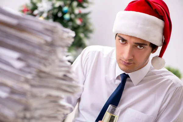 Młody pracownik pracujący w biurze na świątecznej zmianie — Zdjęcie stockowe