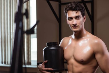 Spor salonunda besin takviyesi olan bir adam.