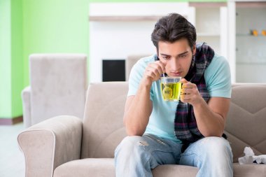 Evde hastalıktan muzdarip genç yakışıklı bir adam. 