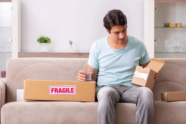 Hombre abriendo frágil paquete ordenado de internet —  Fotos de Stock