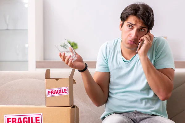 Hombre abriendo frágil paquete ordenado de internet —  Fotos de Stock