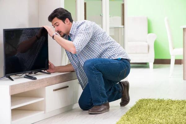 Молодий чоловік чоловік ремонтує телевізор вдома — стокове фото