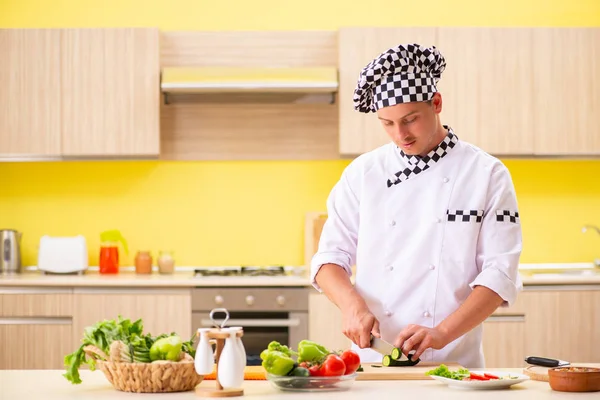 Joven cocinero profesional preparando ensalada en la cocina — Foto de Stock