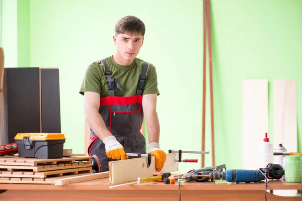 Jongeman timmerman werkt in werkplaats — Stockfoto