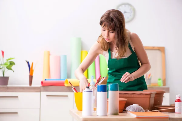 Молодая женщина украшает керамику в мастерской — стоковое фото