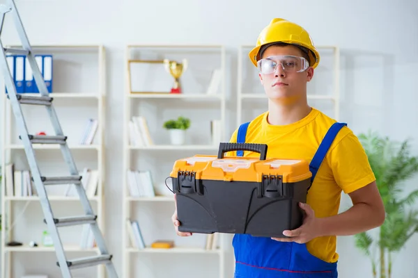 Jovem empreiteiro fazendo obras de reparação no escritório — Fotografia de Stock