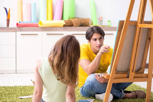 Jovem casal curtindo pintura em casa — Fotografia de Stock