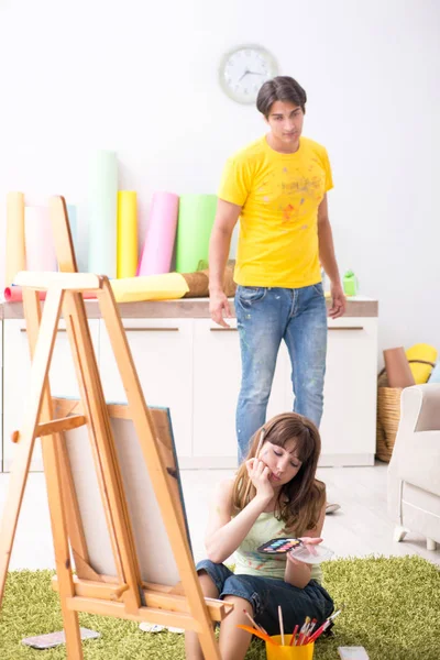 Jovem casal curtindo pintura em casa — Fotografia de Stock