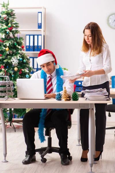 Man and woman working at the office on Cristmass eve