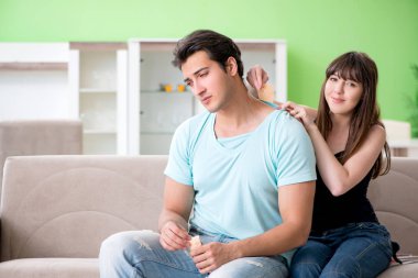 Kadın acıdan kurtulmak için kocaya biber kapsicum sıva uyguluyor.