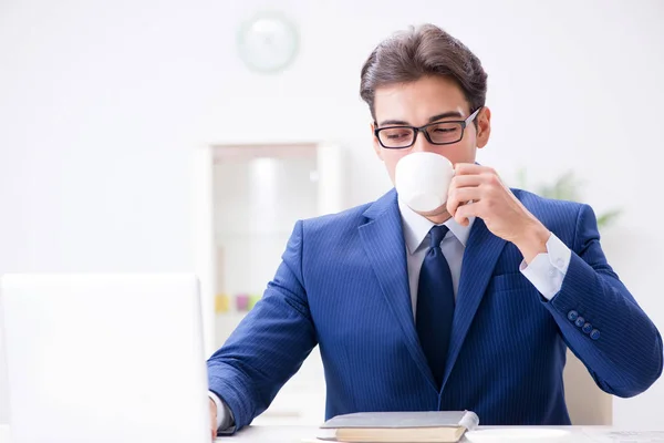 Jeune homme d'affaires beau buvant du café dans le bureau — Photo