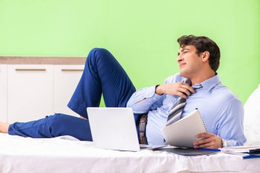 Otel odasında fazla mesai yapan bir iş adamı.