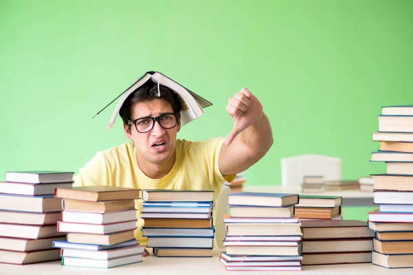 Студент, у которого слишком много книг, чтобы их прочитать перед экзаменом — стоковое фото