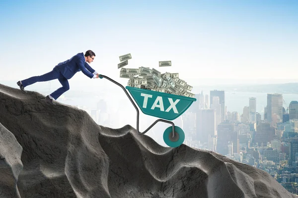 Бизнесмен толкает тележку на налоговые деньги — стоковое фото