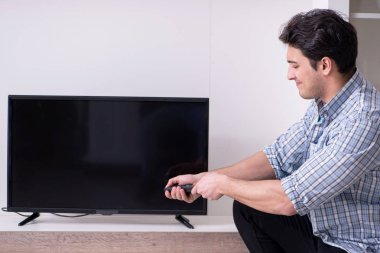 Bozuk televizyonu tamir etmeye çalışan adam
