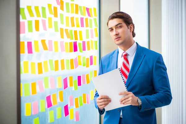 Joven empleado guapo con muchas prioridades contradictorias — Foto de Stock