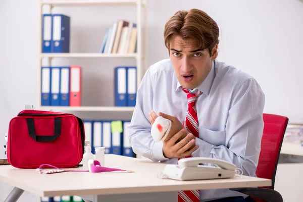 Man with first aid kit in the office