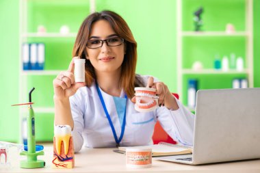 Diş implantı üzerinde çalışan kadın dişçi.