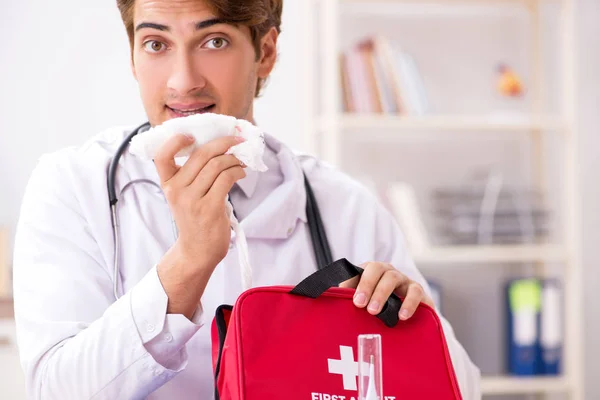 Junger Arzt mit Verbandskasten im Krankenhaus — Stockfoto