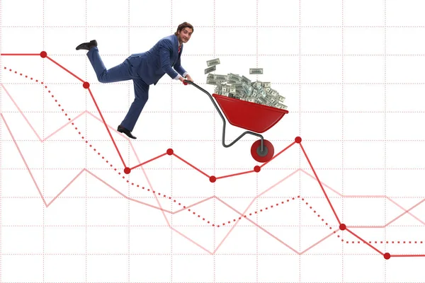 Üzletember nyomja pénz talicska lefelé a diagramon — Stock Fotó