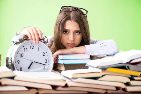 Joven estudiante preparándose para los exámenes con muchos libros a tiempo — Foto de Stock