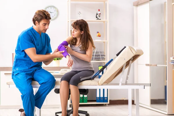 Young tennis player visiting doctor traumatologist