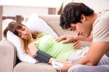 Koca hamile eşlerin tansiyonunu ölçüyor.