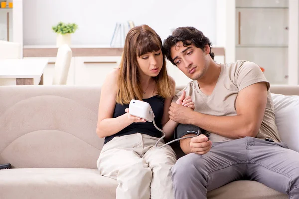 Ehefrau überprüft Blutdruck ihrer Ehemänner — Stockfoto