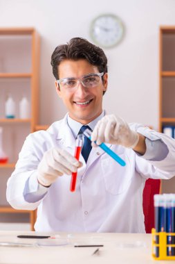 Genç yakışıklı biyokimyacı laboratuvarda çalışıyor.  