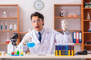 Genç yakışıklı biyokimyacı laboratuvarda çalışıyor. 