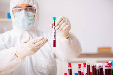 Genç yakışıklı laboratuvar asistanı hastanede kan örnekleri test ediyor. 