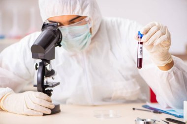 Genç yakışıklı laboratuvar asistanı hastanede kan örnekleri test ediyor. 