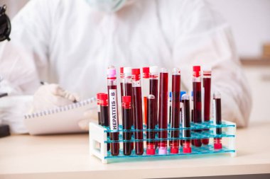 Genç yakışıklı laboratuvar asistanı hastanede kan örnekleri test ediyor. 