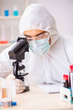 Genç yakışıklı laboratuvar asistanı hastanede kan örnekleri test ediyor. 