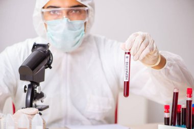 Genç yakışıklı laboratuvar asistanı hastanede kan örnekleri test ediyor. 