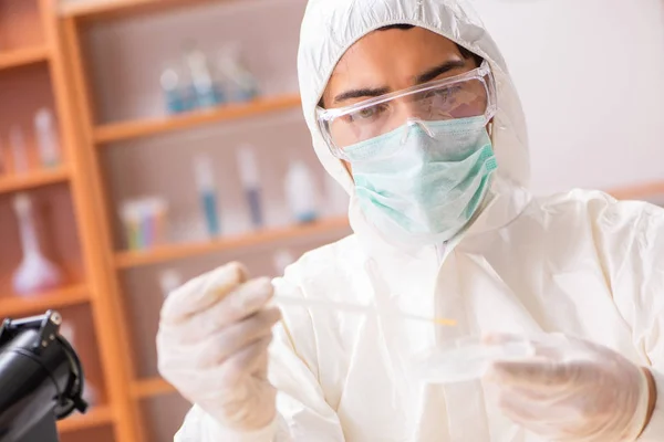 Junge Biochemikerin im Schutzanzug bei der Arbeit im Labor — Stockfoto