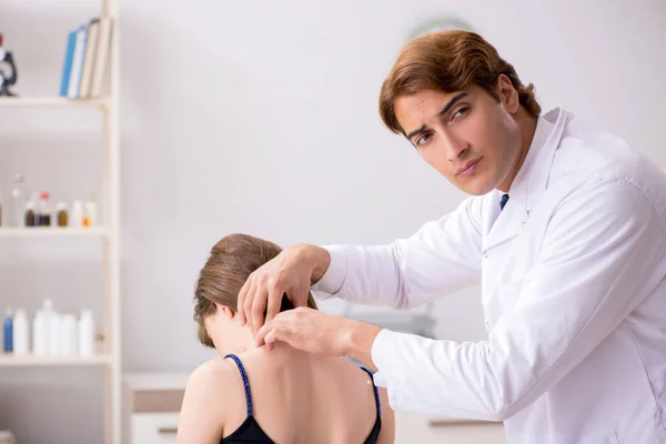 Paciente do sexo feminino visitando jovem bonito médico quiroprático — Fotografia de Stock