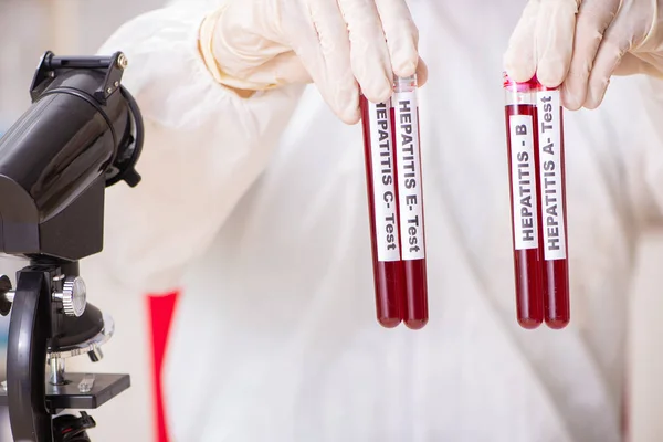 Asistente de laboratorio joven guapo analizando muestras de sangre en el hospital — Foto de Stock