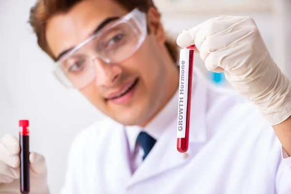 Asistente de laboratorio joven guapo analizando muestras de sangre en el hospital — Foto de Stock