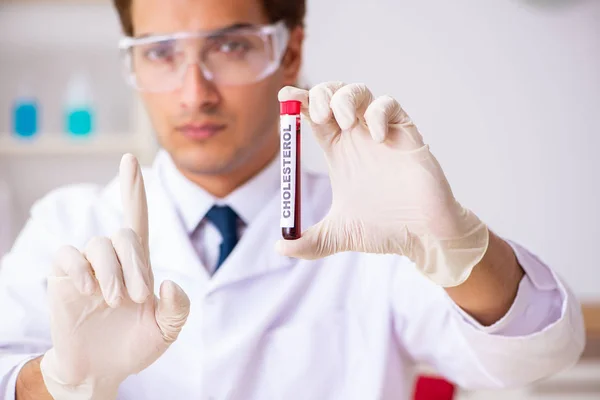 Asistente de laboratorio joven guapo analizando muestras de sangre en el hospital — Foto de Stock