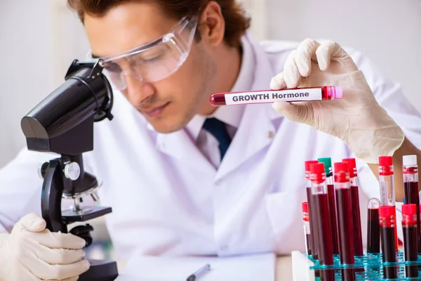 Fiatal jóképű laboratóriumi asszisztens vérmintákat tesztel a kórházban — Stock Fotó