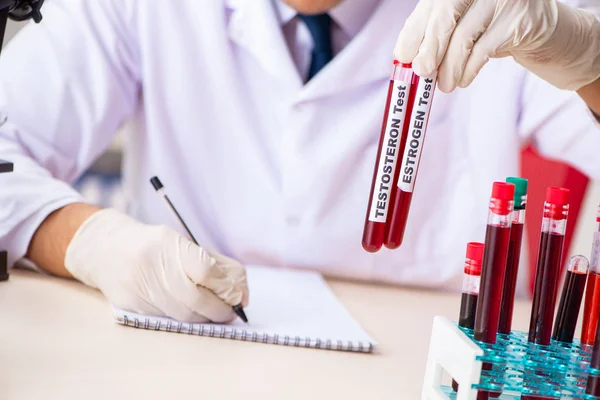 Jovem assistente de laboratório bonito testando amostras de sangue no hospital — Fotografia de Stock